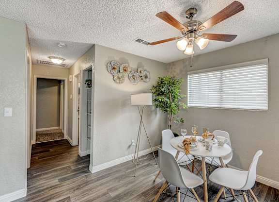a dining room with a table and chairs and a ceiling fan at Desert Bay Apartments, Laughlin, NV