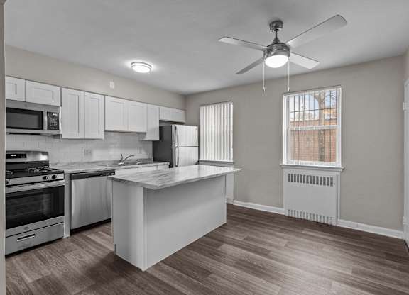 an empty kitchen with an island and a ceiling fan at Hampton Gardens, Missouri, 63139
