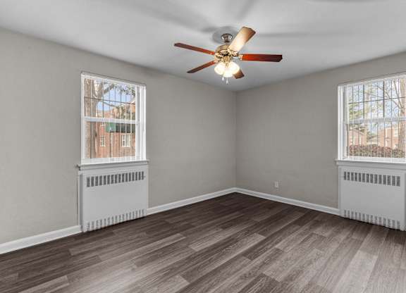 an empty living room with two windows and a ceiling fan at Hampton Gardens, Missouri, 63139
