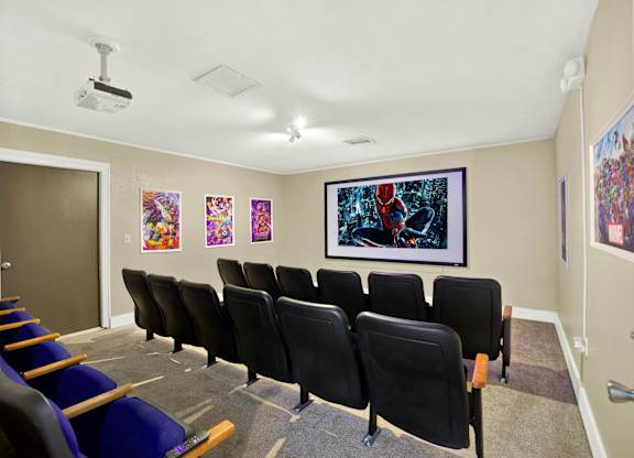 A room with a row of chairs and a painting on the wall.