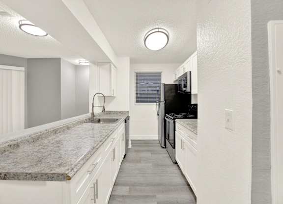 A kitchen with granite countertops and white cabinets. at Village Park, Orlando, FL
