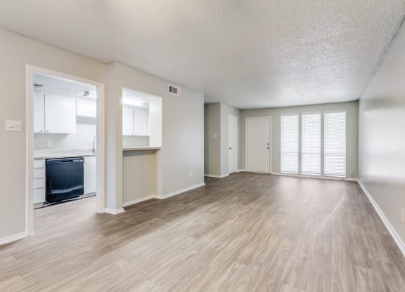 an empty living room and kitchen with a hard wood floor at Falls on Clearwood Apartments, Richardson, TX, Texas