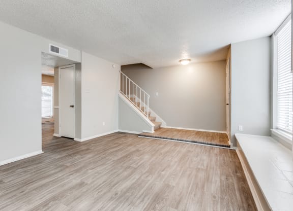 the spacious living room and dining room of an apartment at Falls on Clearwood Apartments, Richardson, TX, Texas