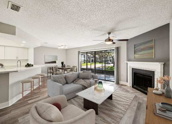 A living room with a grey couch and a fireplace.