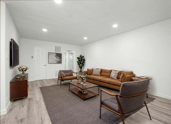 A living room with a brown couch, a chair, and a coffee table.