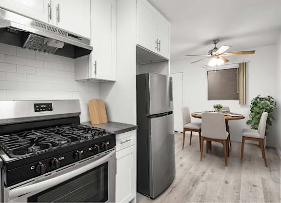 A modern kitchen with a stove, refrigerator, and dining table.