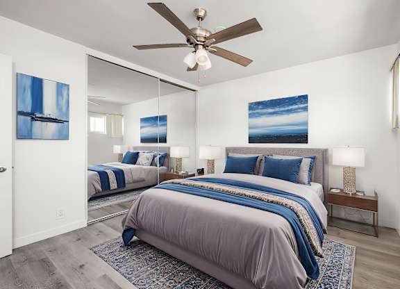 A bedroom with two beds and a ceiling fan.