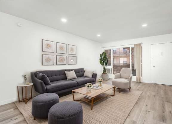 A living room with a grey couch, a coffee table, and a chair.