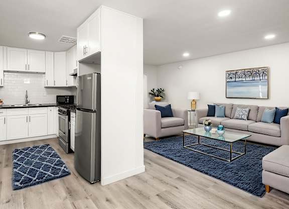 A modern kitchen with a refrigerator, sink, and cabinets.