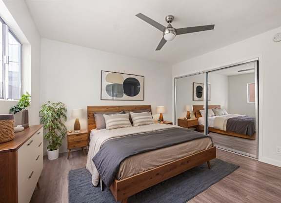 A bedroom with a bed, dresser, and mirror.