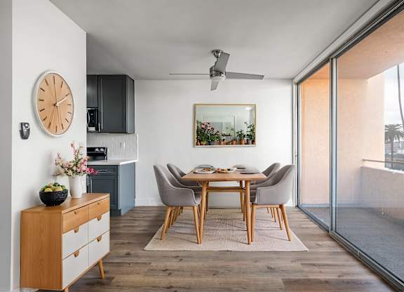 A modern dining room with a wooden table and chairs.
