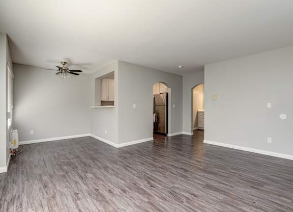 a living room with a ceiling fan and a hard wood floor