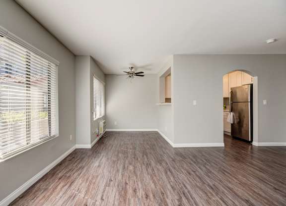 an empty living room with a large window and wood floors