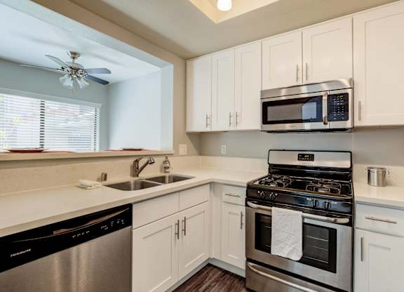 a kitchen with stainless steel appliances and white cabinets