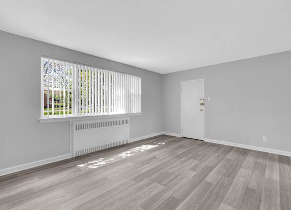 a bedroom with hardwood floors and grey walls at Hampton Gardens, Saint Louis, MO, 63139