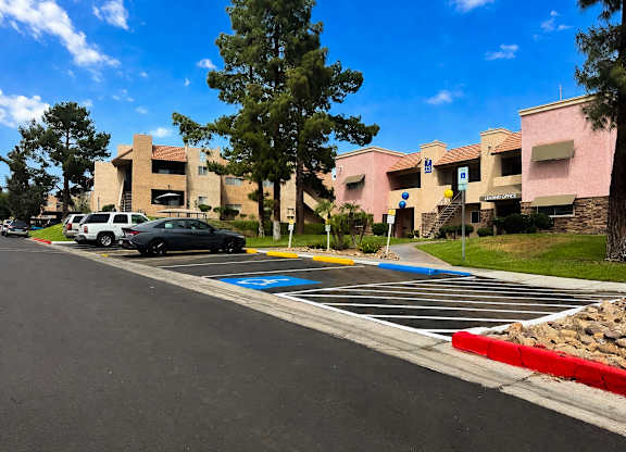 A parking lot with cars and a building in the background.