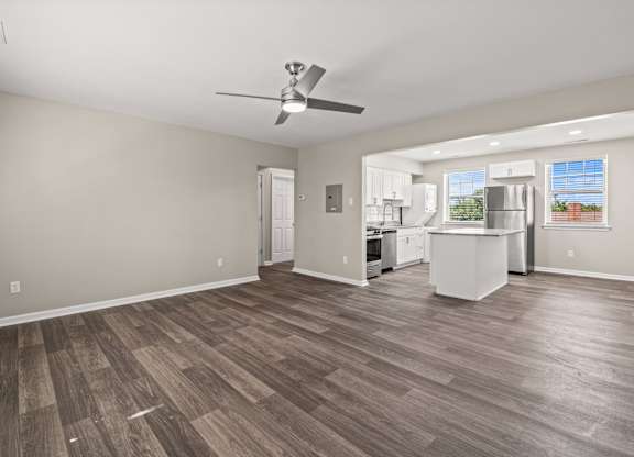 a living room with a ceiling fan and a kitchen in the background at Hampton Gardens, Saint Louis