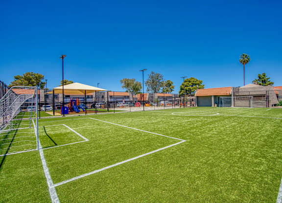 A tennis court with a white line and a yellow canopy tent.