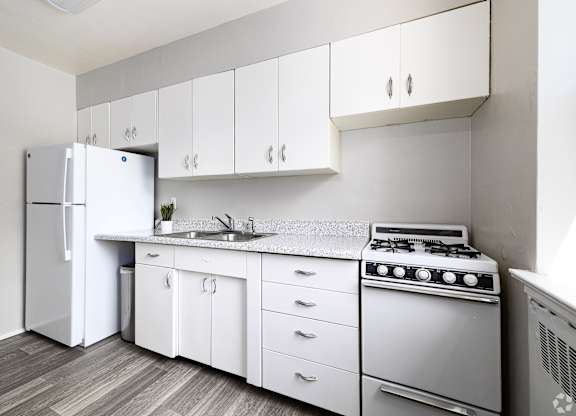 a kitchen with white cabinets and a stove and refrigerator at Hampton Gardens, Missouri, 63139