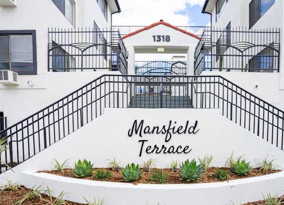 the entrance to the terrace building with the entrance sign to the building