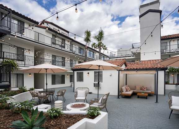 a courtyard with tables and chairs and umbrellas
