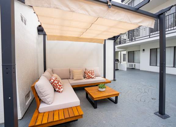 a patio with two couches and a wooden table