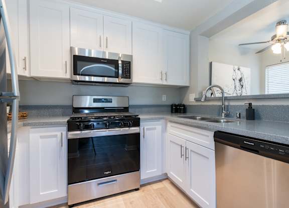 a kitchen with stainless steel appliances and white cabinets