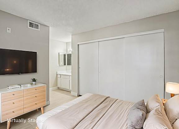 A bedroom with a bed, dresser, and mirror.
