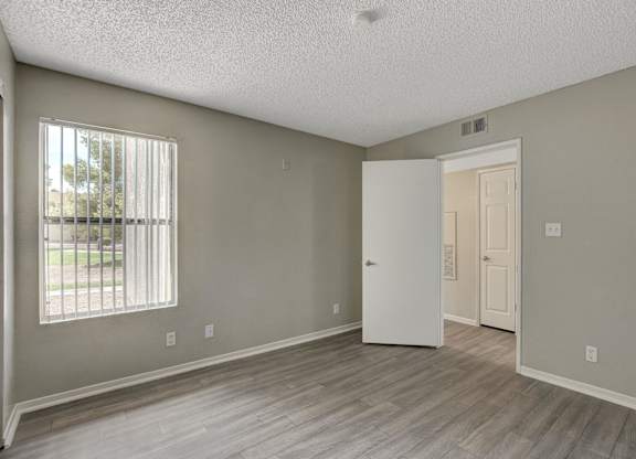 A room with a white door and a window with blinds.