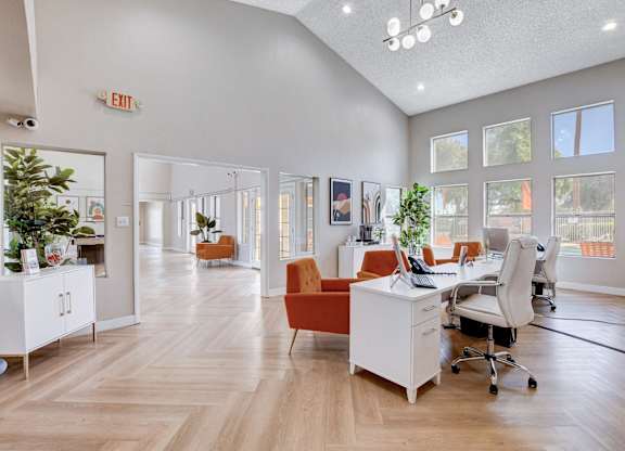 A brightly lit office space with wooden floors and white walls.