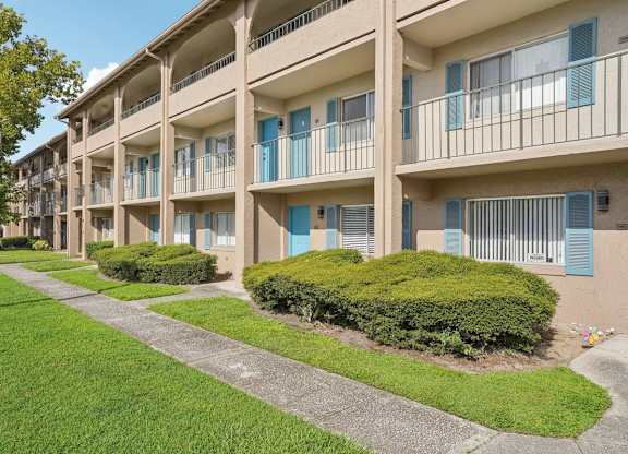 Apartment complex with green bushes in front.
