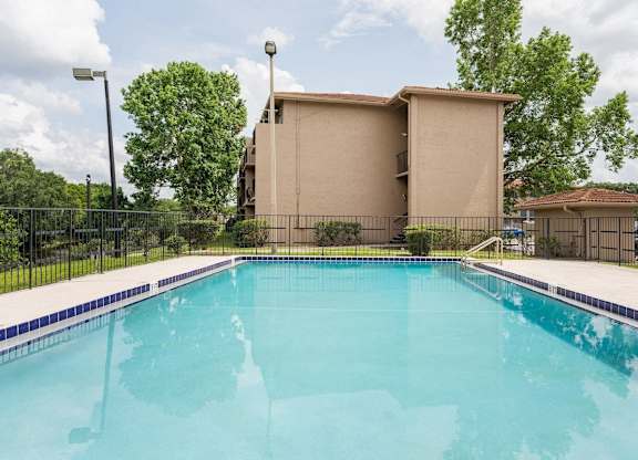 A swimming pool in front of a house.