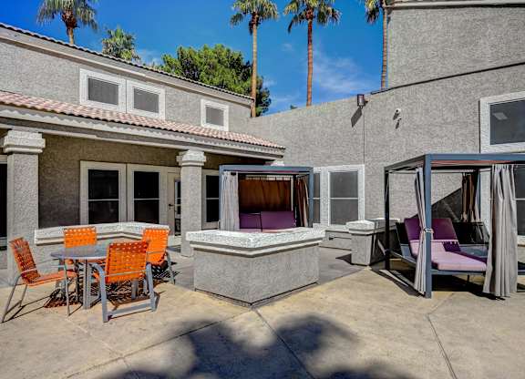 A patio with a table and chairs and a hot tub.
