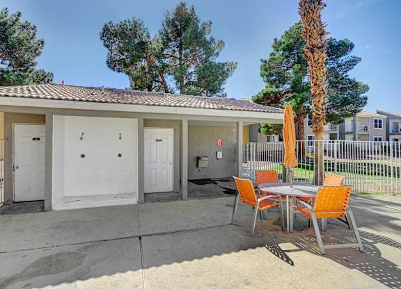 A patio with a table and chairs is set up outside a house.