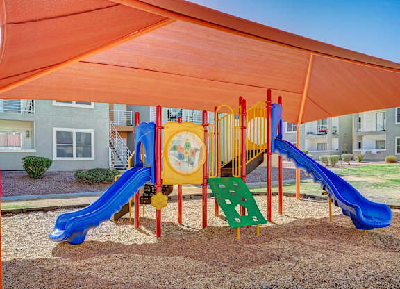 A playground with a blue slide and a yellow and red play structure.