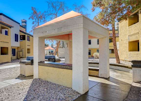 A small white structure sits in the middle of a courtyard.