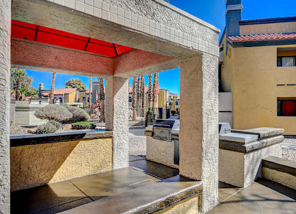 A patio with a red awning and a concrete bench.