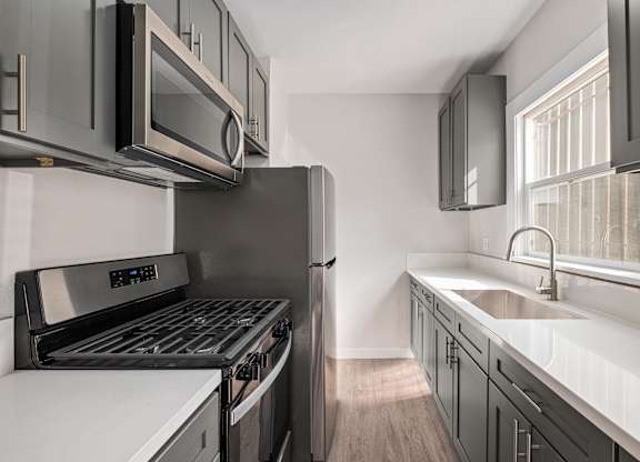 A modern kitchen with stainless steel appliances and wooden floors at Hillstone Flats Apartments, Los Angeles, CA, 90004