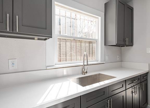A kitchen with a white countertop and a window at Hillstone Flats Apartments, Los Angeles, California