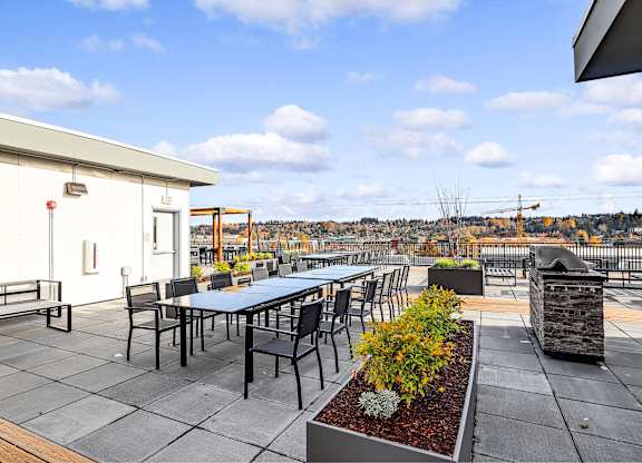 A patio with a table and chairs overlooking a cityscape.