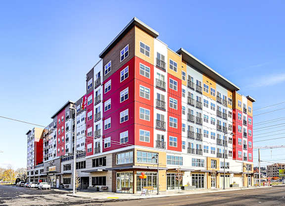 A large, modern multi-story building with a mix of red, yellow, and white colors.