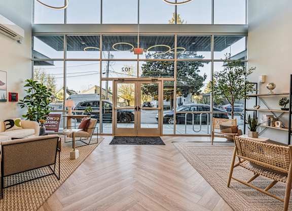A modern waiting area with a glass wall and wooden floors.