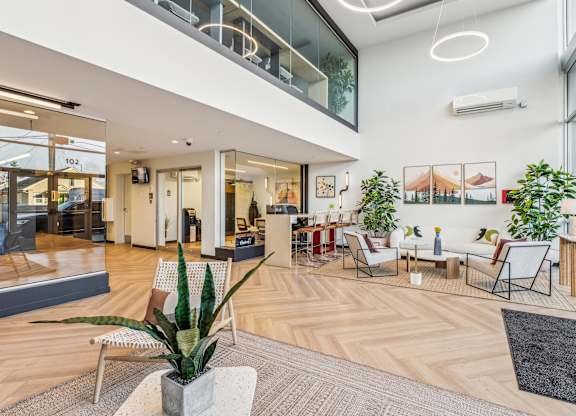 A modern office space with wooden floors and a variety of seating options.