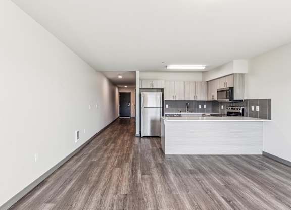 A kitchen with a refrigerator, microwave, and oven.