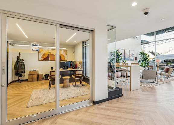 A modern office space with a glass door entrance and a view of the outside.