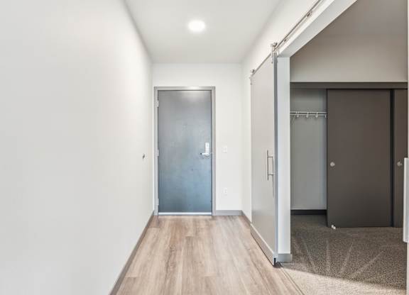 A hallway with a wooden floor and a glass door.