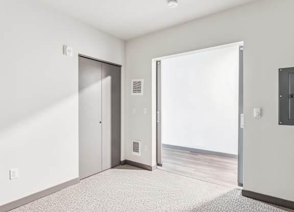 A white room with a carpeted floor and a white door.