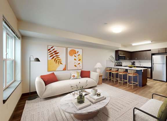 A modern living room with a white sofa, a grey armchair, a coffee table, and a kitchen in the background.