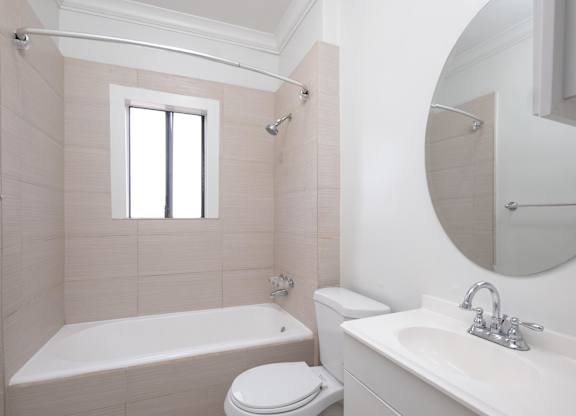 A white bathroom with a toilet, sink, and bathtub at Mariposa Willows Apartments, Los Angeles, CA