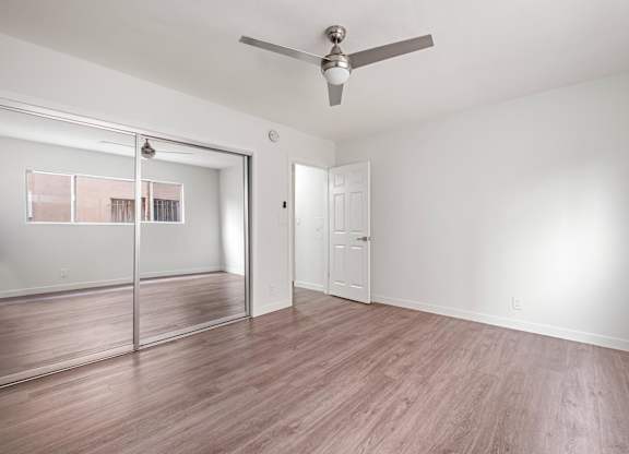 A room with a ceiling fan and a sliding glass door at Menlo Terrace Apartments, Los Angeles, California